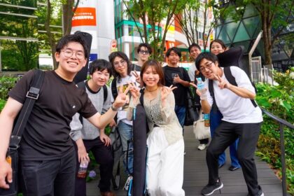Members of the Tokyo band Bell Peppers posing with their instrument cases on a city street
